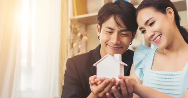 cặp đôi trẻ nhìn vào mô hình ngôi nhà